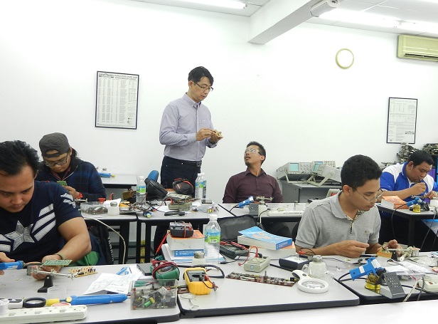teaching students in electronics repair