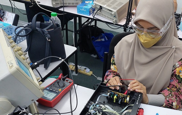 lady doing electronics repair work